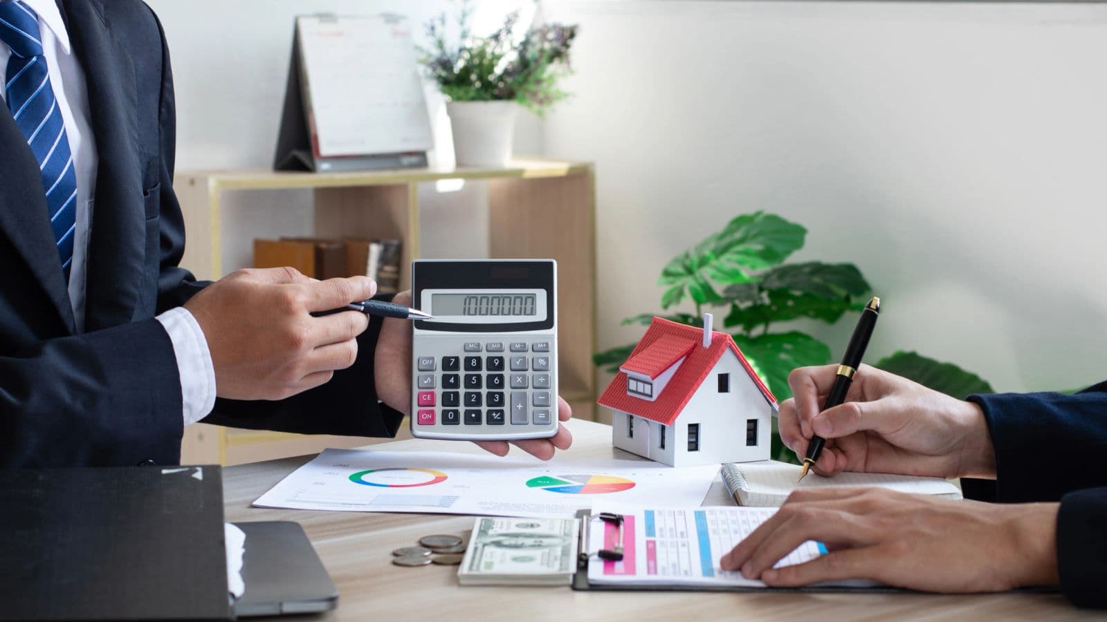 Calculator and model house representing landlord insurance
